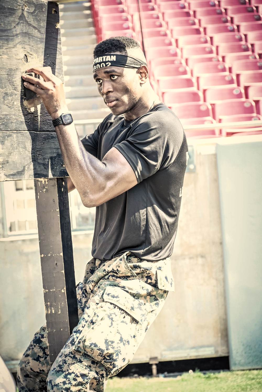 Gripping the top edge of the wall obstacle at the Spartan Stadion